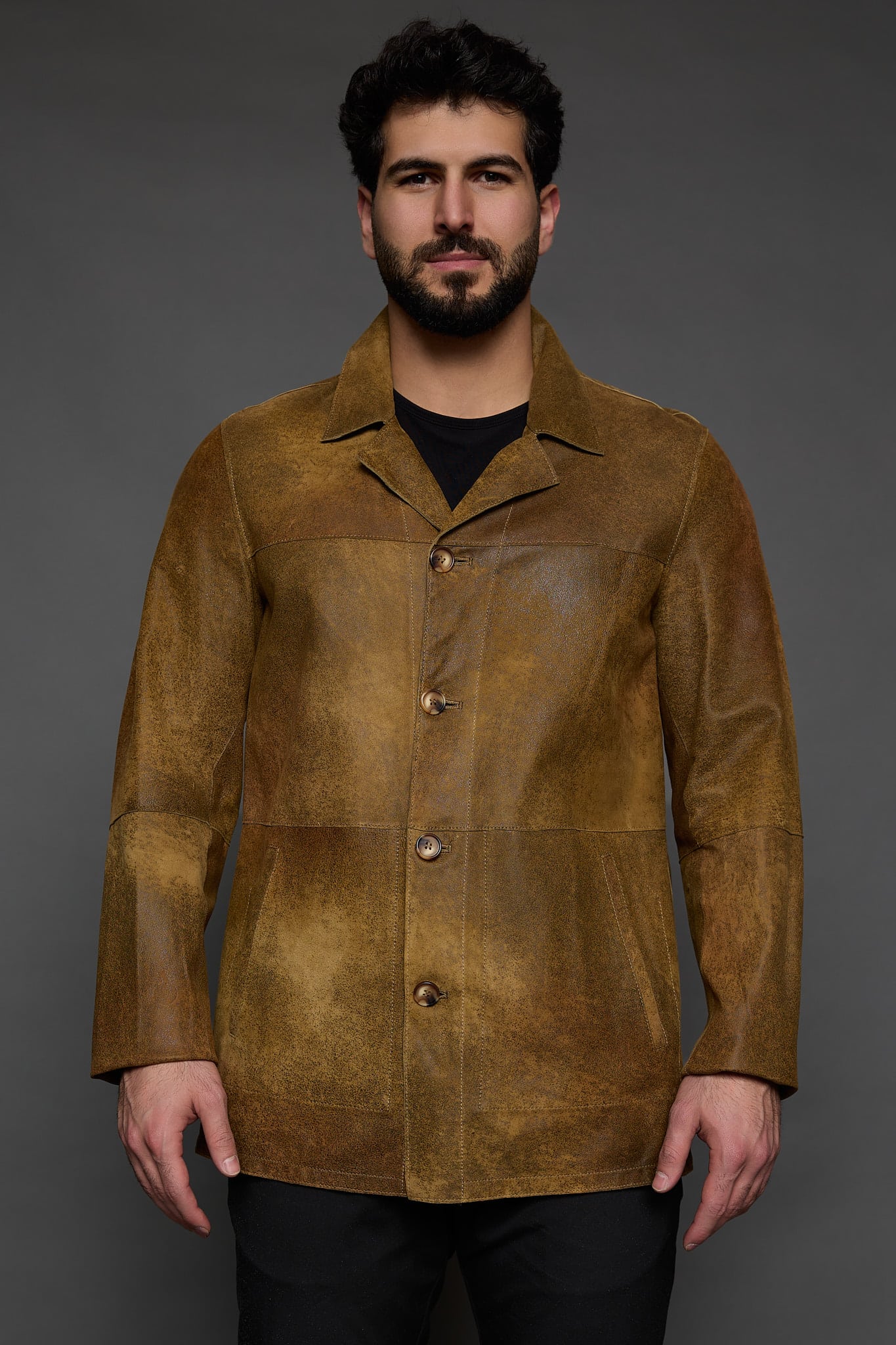 man in a brown jacket against a grey background