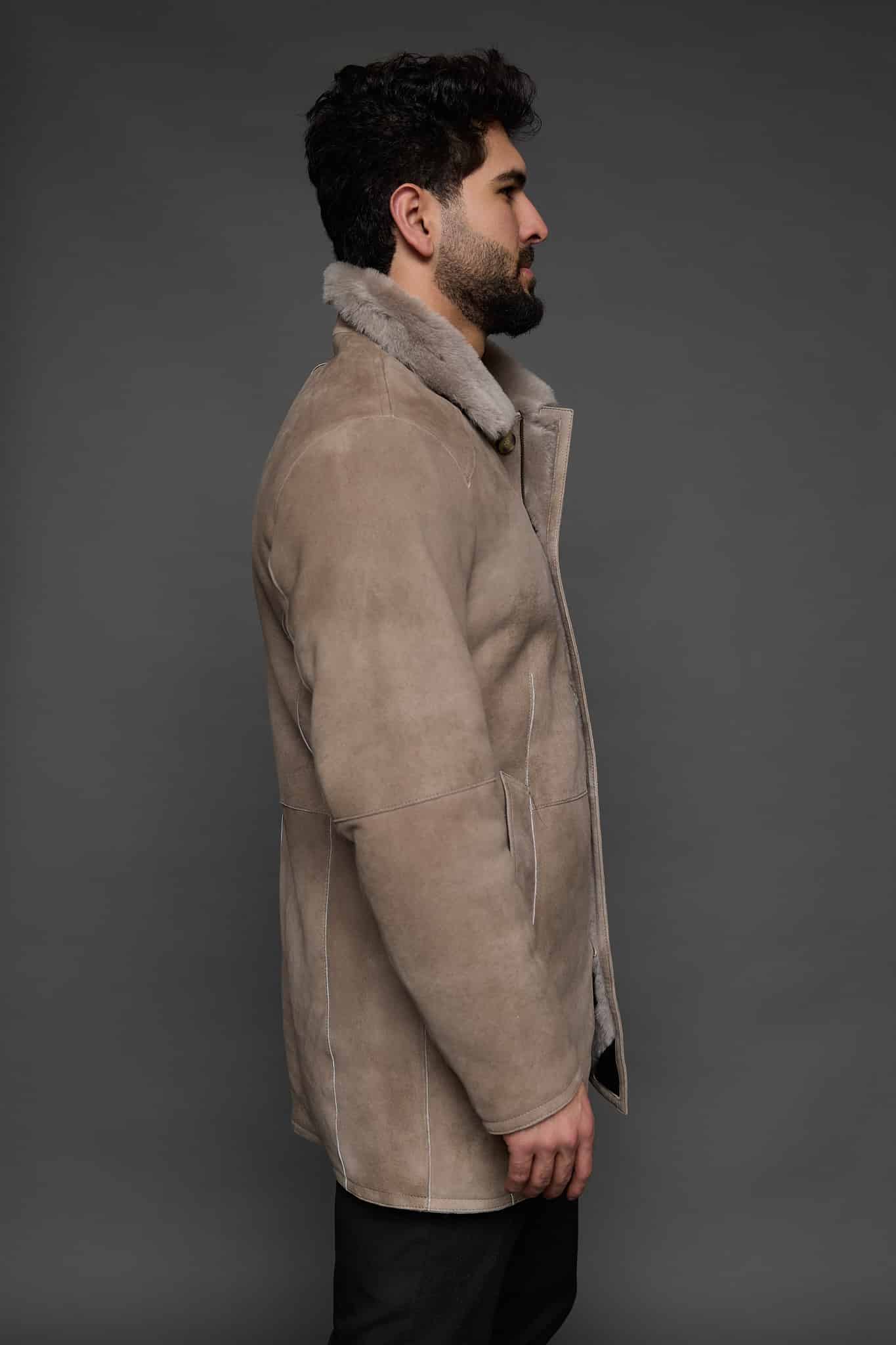 the side of a man in a tan coat against a grey background
