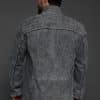 the back of a man in a grey jacket against a grey background