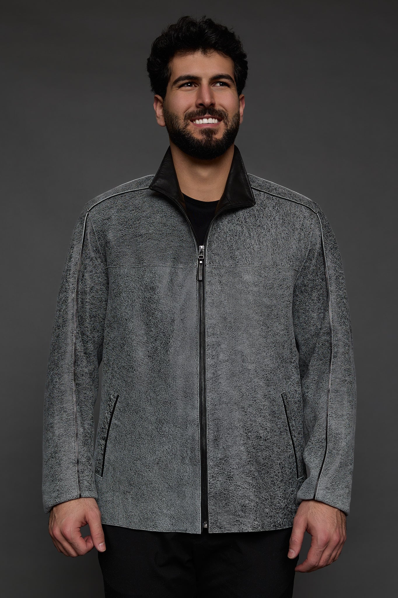 man in a grey jacket against a grey background