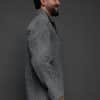 the profile of a man in a grey jacket against a grey background