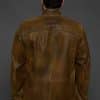 the back of a man in a brown jacket against a grey background