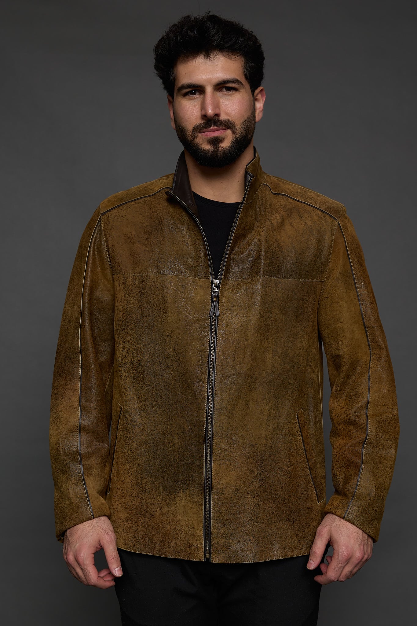 man in a brown jacket against a grey background