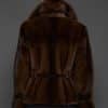 Reverse angle of a woman in a mahogany mink jacket facing a dark grey background