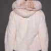 the back of a woman in a white fur jacket against a grey background