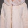 a close up detail of a woman in a white fur jacket against a grey background