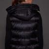 ANDI LYNX PUFFER VEST BLACK BACK the back of a woman in a black vest against a grey background