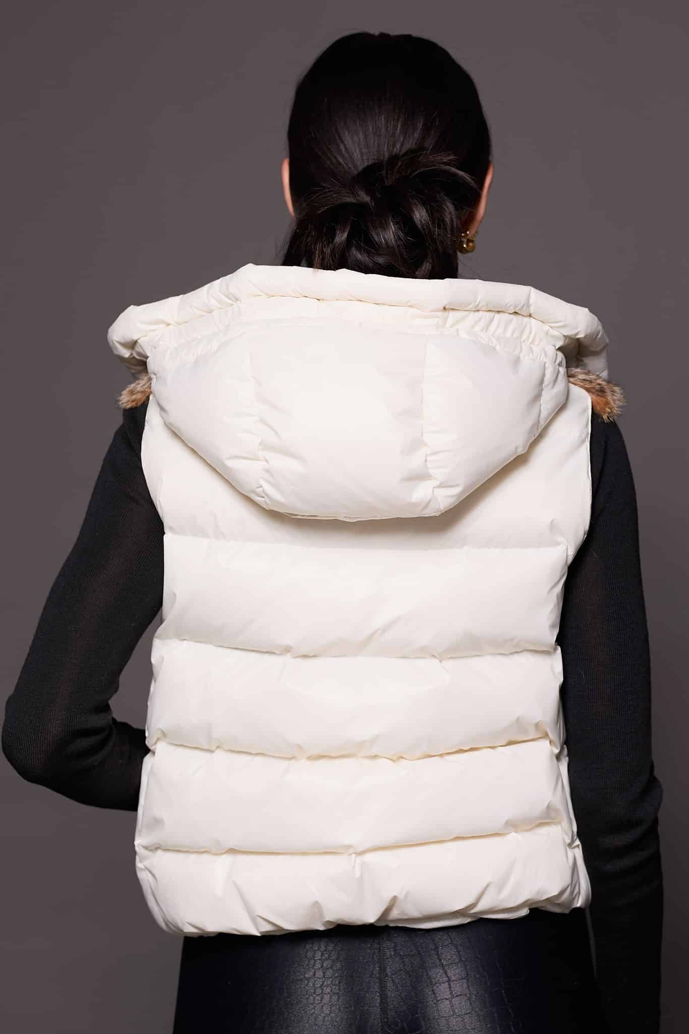 Andi Lynx Puffer Vest White Back the back of a woman wearing a white puffer vest with lynx fur against a solid grey background