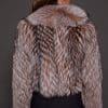 the back of a woman in a brown fur jacket against a grey background