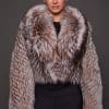 the front of a woman in a brown and white fur jacket against a grey background