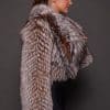 the side profile of a woman in a brown fur jacket against a grey background