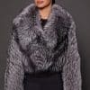 the front of a a woman in a silver fur jacket against a grey background