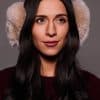 woman wearing beige earmuffs against a grey background