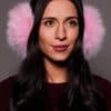woman wearing pink earmuffs against a grey background