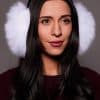 woman wearing white earmuffs against a grey background