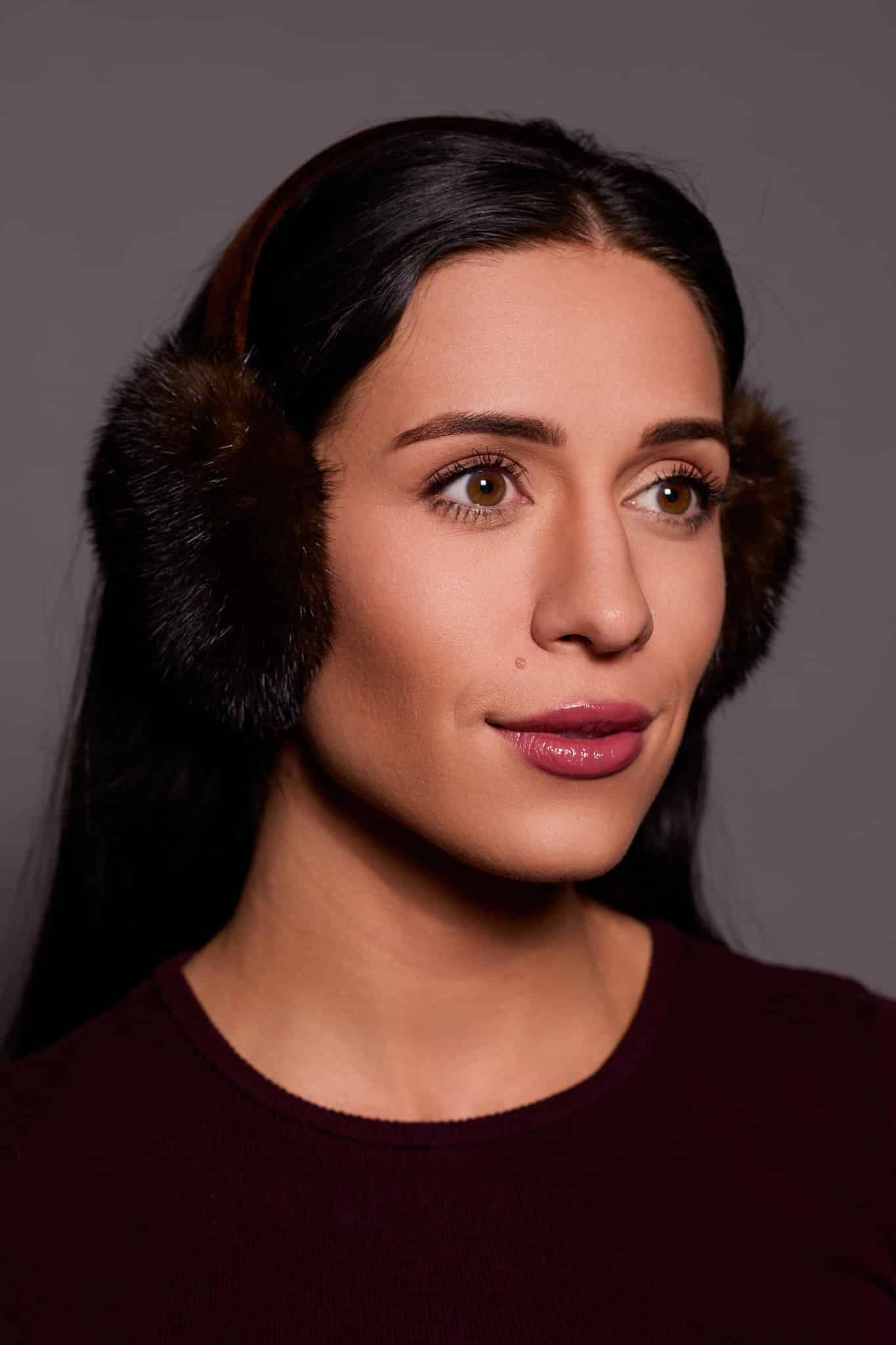 woman in brown earmuffs against a grey background