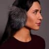 woman wearing grey earmuffs against a grey background