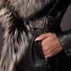 up close image of the hand of a woman in the pocket of a black leather jacket with fur trim