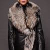 the front of a woman in a black leather jacket with a brown fur trim against a dark grey background