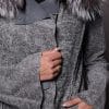 close up detailed image of a woman in a grey leather jacket with fur against a grey backdrop