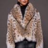 the front of a woman in a lynx fur coat against a grey background