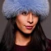 Frontal portrait shot of a woman wearing a blue colored fox fur headband.