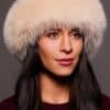 Frontal portrait shot of a woman wearing a blush colored fox fur headband.