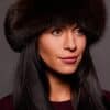 Frontal portrait shot of a woman wearing a brown colored fox fur headband.