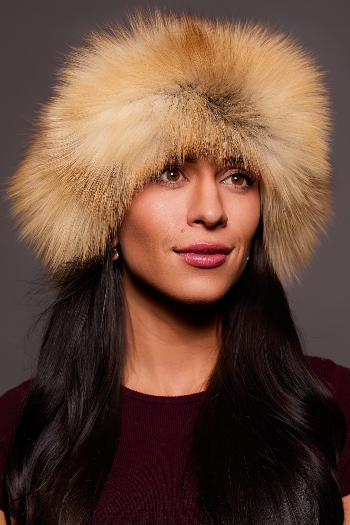 Frontal portrait shot of a woman wearing a golden isle colored fox fur headband.