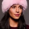 Frontal portrait shot of a woman wearing a pink colored fox fur headband.