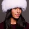 Frontal portrait shot of a woman wearing a white colored fox fur headband.