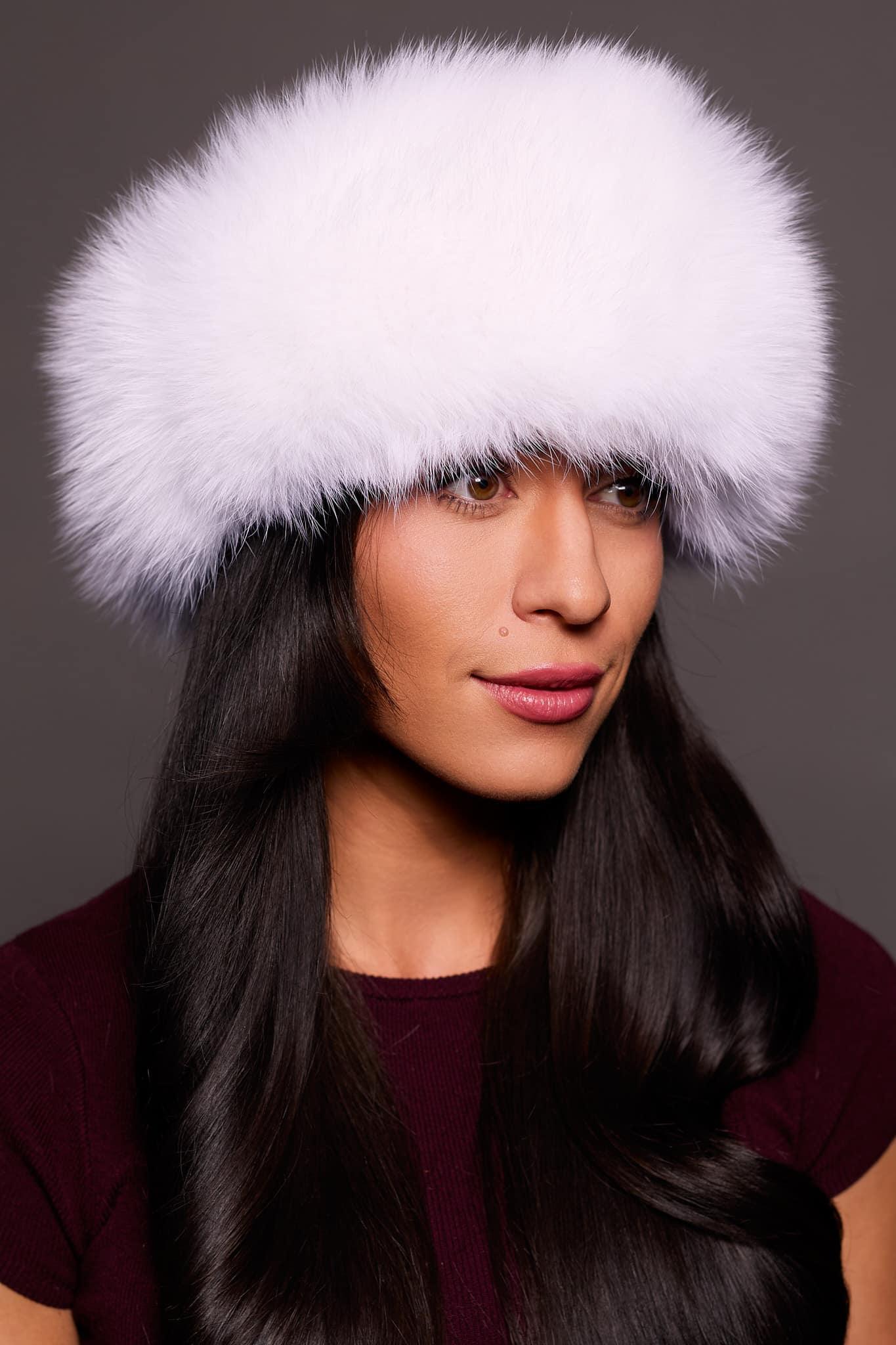 Frontal portrait shot of a woman wearing a white colored fox fur headband.