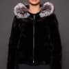 GIA MINK BLACK SILVER FOX FRONT the front of a woman in a black and grey fur jacket against a grey background