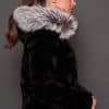 GIA MINK BLACK SILVER FOX SIDE the side of a woman in a black and grey fur jacket against a grey background