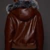 the back image of a woman in a brown jacket with a silver fur trim on the hood against a grey background