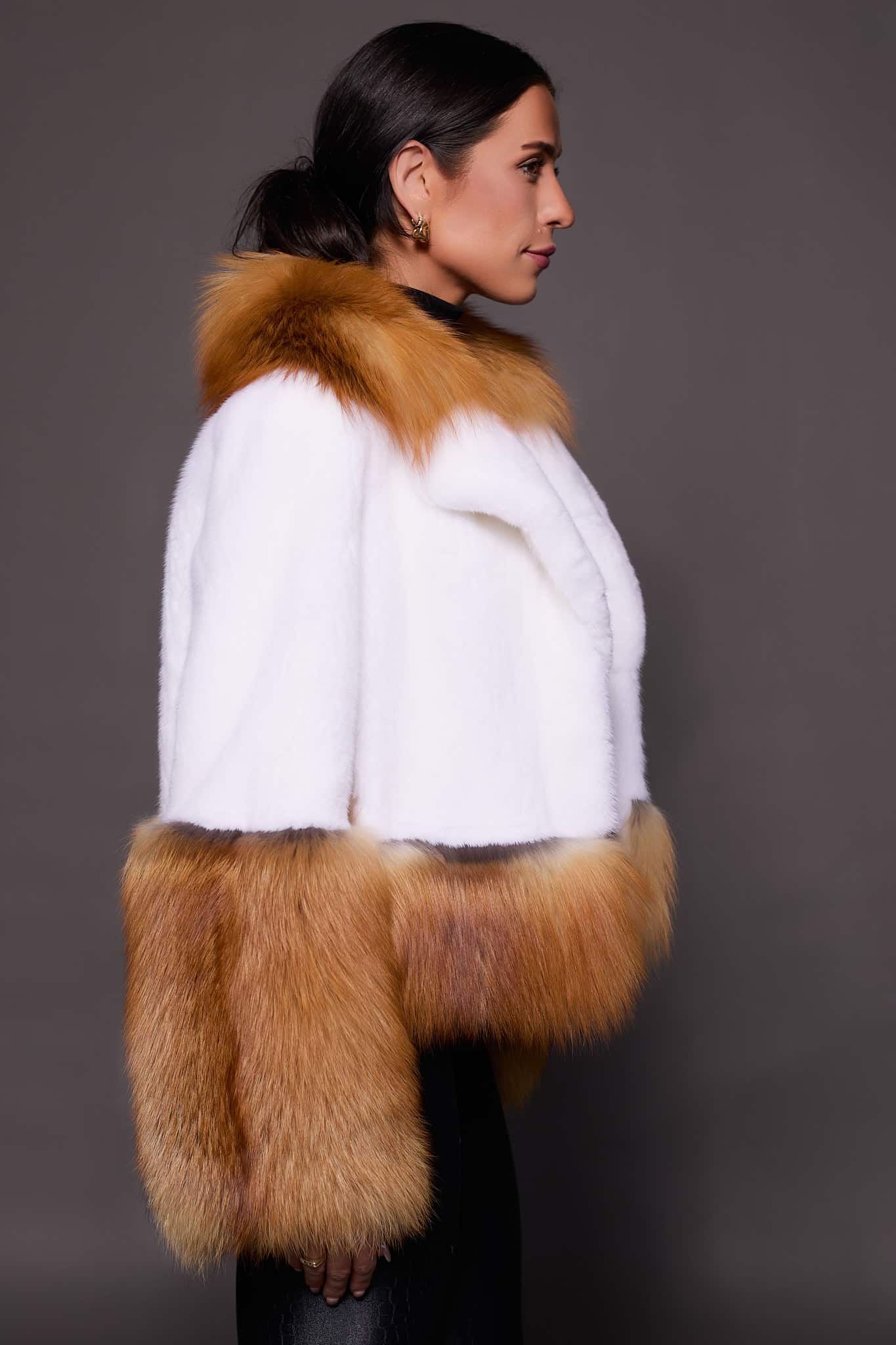 MARLEY MINK JACKET RED FOX SIDE the side of a woman in a red and white fur jacket against a grey backdrop