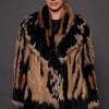 SASCHA REX KNIT BLACK FRONT the front of a woman in a black and brown fur knitted jacket against a grey background
