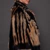 SASCHA REX KNIT BLACK SIDE the side of a woman in a black and brown fur knitted jacket against a grey background