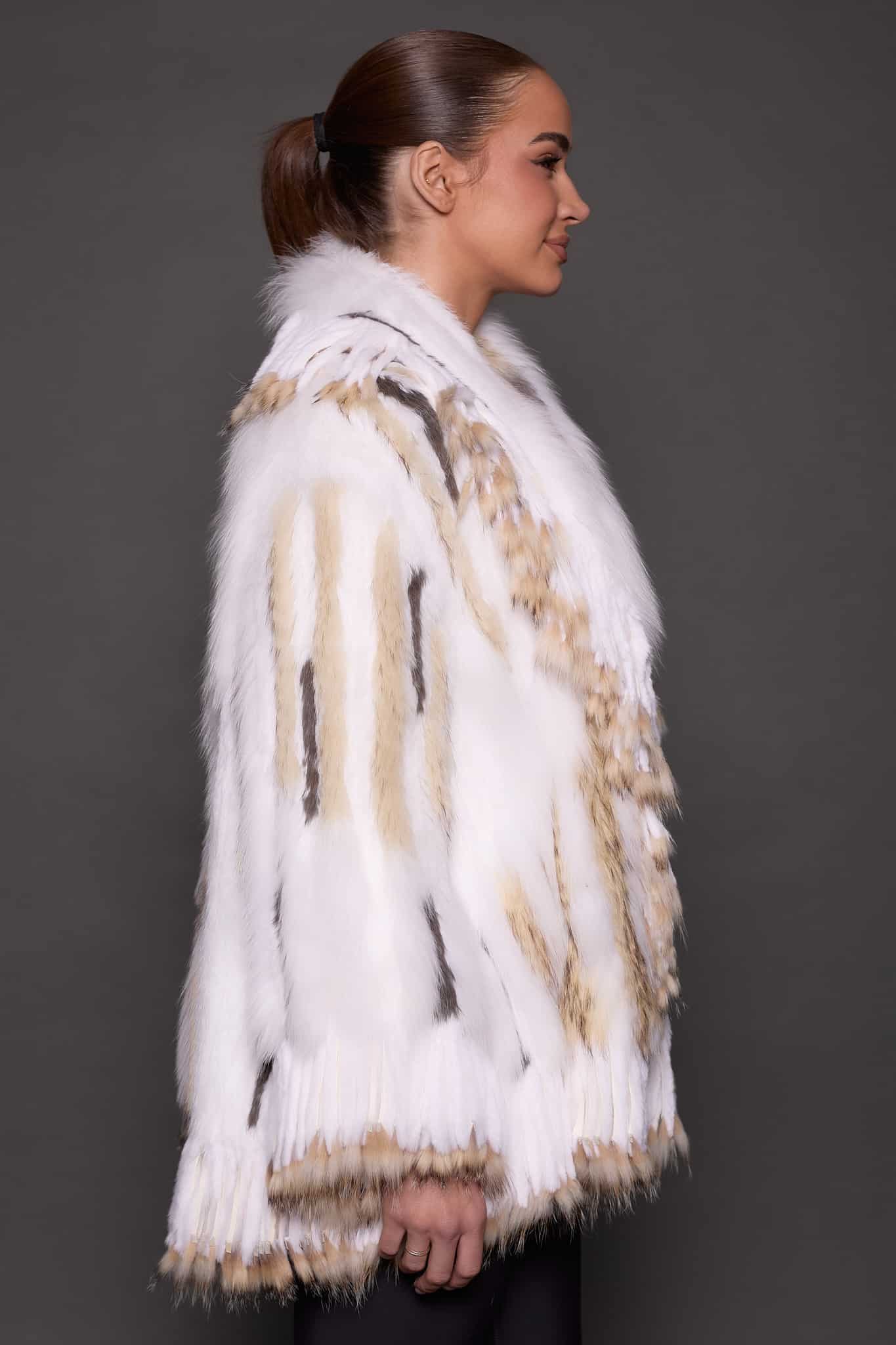 SASCHA REX KNIT WHITE SIDE the side of a woman in a white fur knitted jacket against a grey background