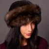 High angle frontal view of a woman wearing a ranch mink fur and Russian sable fur hat standing in front of a grey background.